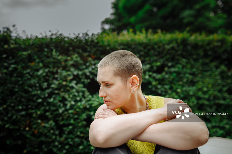 化疗后坐在公园长椅上的中年女性享受宁静时刻图片素材