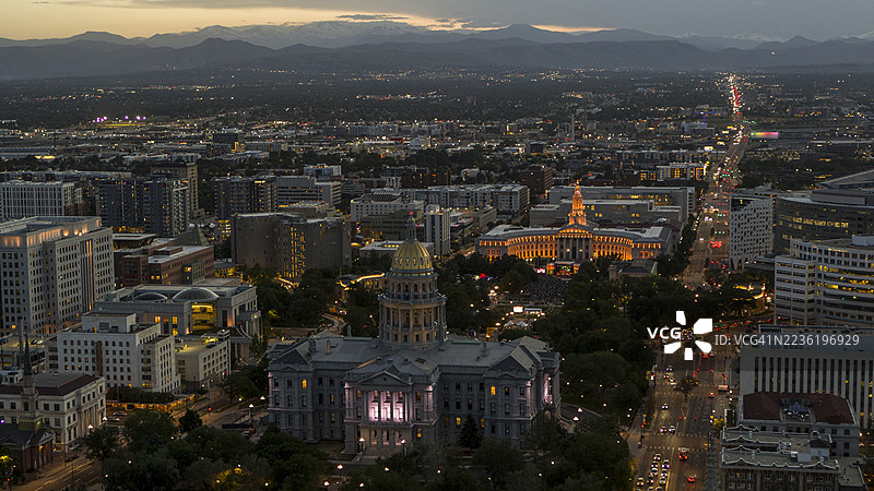 落基山脉背景在黄昏时框住了国会山区。城市灯光照亮了科罗拉多州丹佛市，包括市政中心公园和政府大楼。图片素材