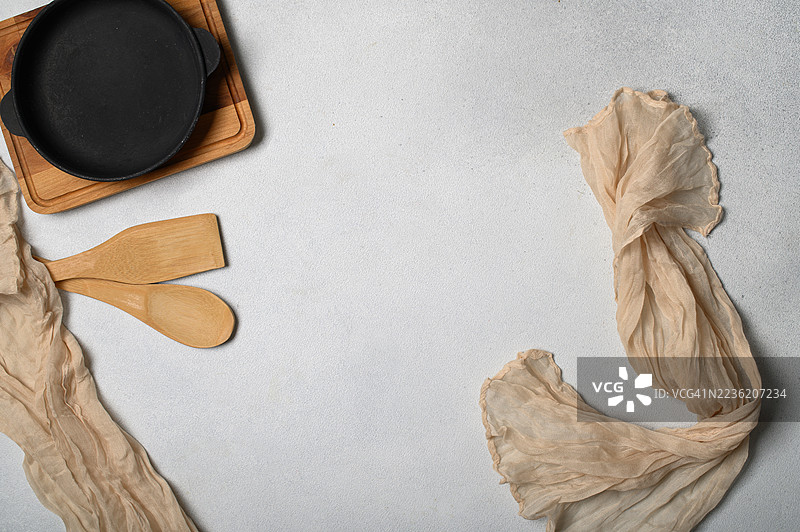 浅色背景上的厨房用具和平底铸铁锅的平铺展示图片素材