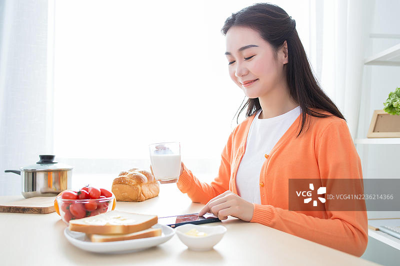 一位女性享用健康的早餐，搭配多种食物图片素材