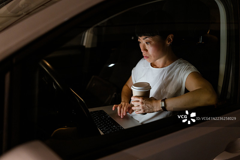 现代生活场景，一位日本女性在平衡咖啡和笔记本电脑。图片素材