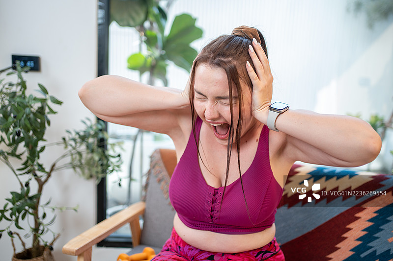 肥胖的女人对自己的肚子感到不悦，她正在触摸自己肥胖的腹部，并希望减肥。这位超重的女性正为自己的体重、饮食和生活方式感到担忧。图片素材