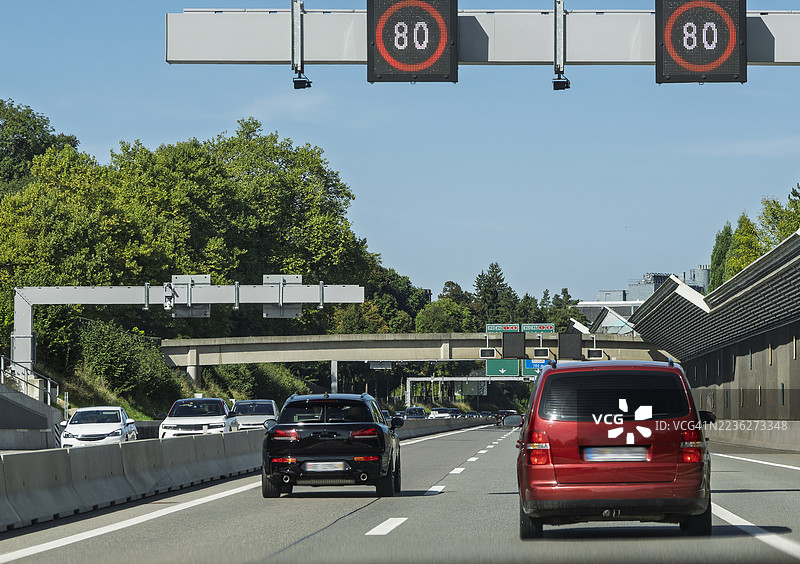 从车内视角看，瑞士高速公路因施工而设立的限速交通标志。图片素材