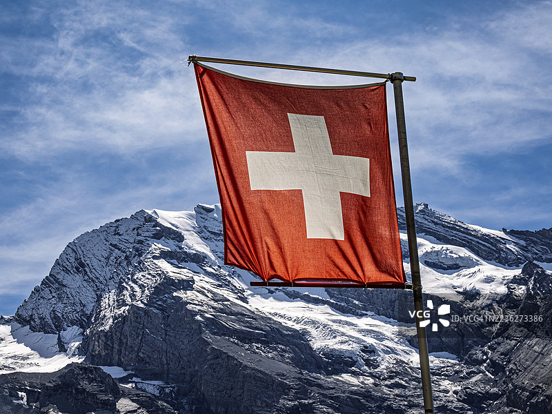 瑞士国旗在瑞士阿尔卑斯山海拔超过3000米的山峰上飘扬。图片素材