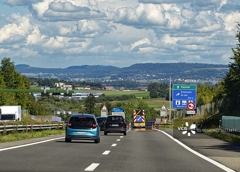 从车内视角看，交通标志显示由于瑞士高速公路的施工而减少车道。图片素材