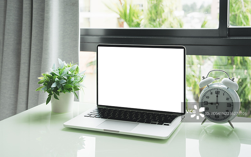 咖啡馆背景下的桌子上放着一台空白屏幕的笔记本电脑。咖啡店模糊背景中的桌子上有一台空白屏幕的笔记本电脑。图片素材