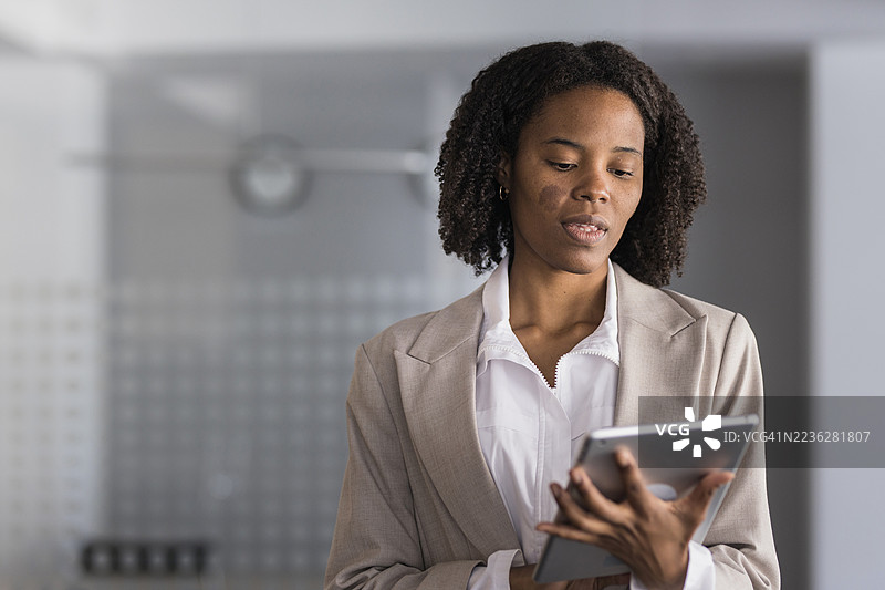 黑人女商人在办公室使用数字平板电脑图片素材