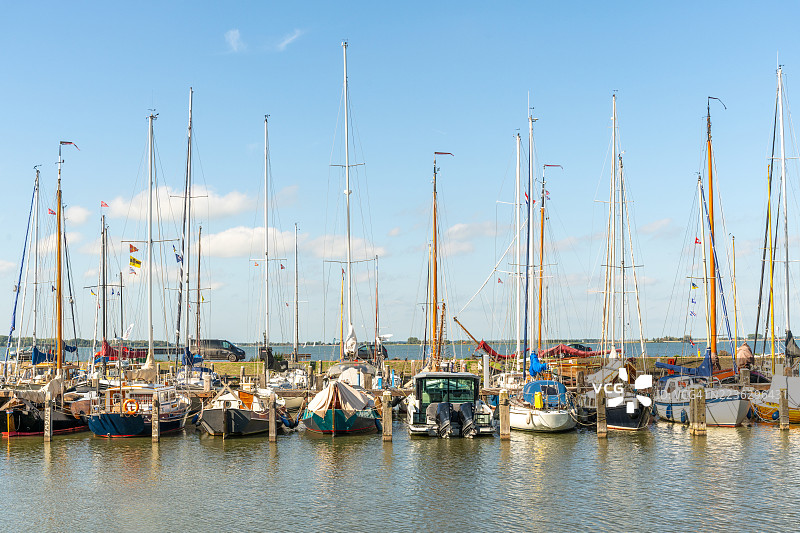 阳光明媚的日子里，停泊在码头的帆船图片素材