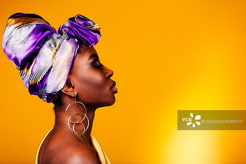 美丽的非洲裔女性肖像。头上披着五彩斑斓的头巾的非洲女性。图片素材