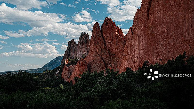 生动的红色岩石形成物在蓝天和白云的衬托下，展现出自然风光的壮丽低角度视图图片素材