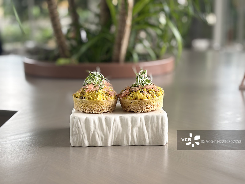 白色托盘上的两款美味开胃菜特写，配有微型绿叶，摆放在现代桌子上图片素材