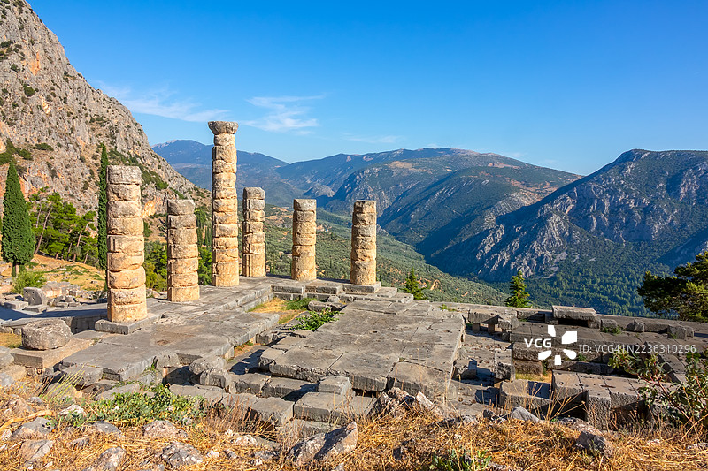 希腊德尔斐阿波罗神庙的古老遗址，背景是令人惊叹的山谷，天空湛蓝清澈图片素材
