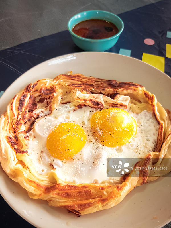 高角度视图的美味早餐，盘子里盛着煎蛋和印度薄饼，旁边配有调味酱。图片素材