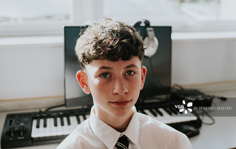 教室里一位穿着校服的年轻男孩肖像。图片素材