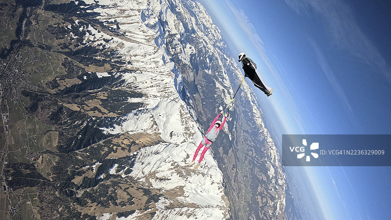 空中飞人从飞机上跳下，翱翔在山脉风景之上图片素材