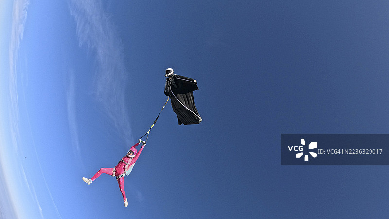 空中飞人从飞机上跳下，翱翔在山脉风景之上图片素材
