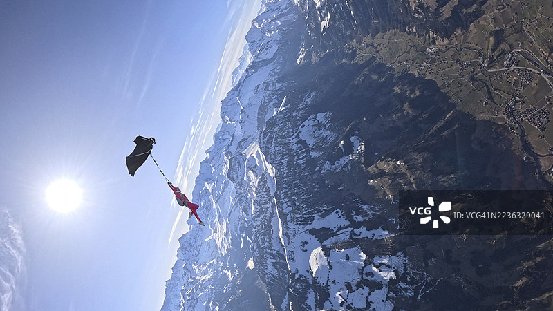 空中飞人从飞机上跳下，翱翔在山脉风景之上图片素材