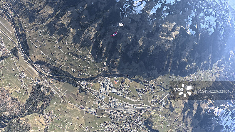 空中飞人从飞机上跳下，翱翔在山脉风景之上图片素材