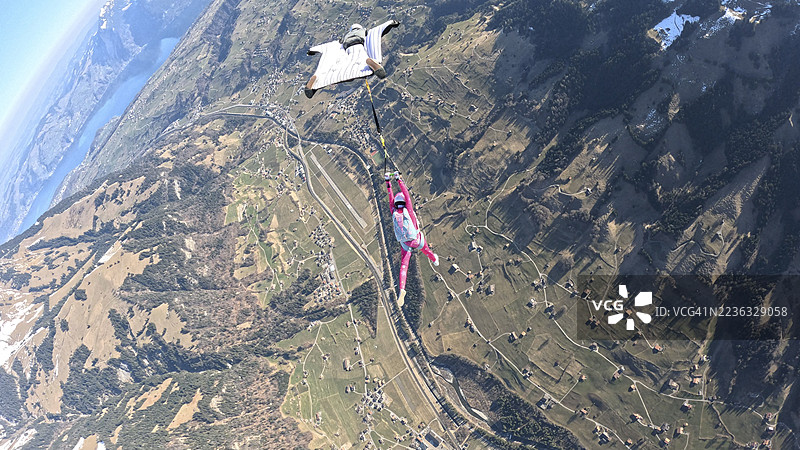 空中飞人从飞机上跳下，翱翔在山脉风景之上图片素材