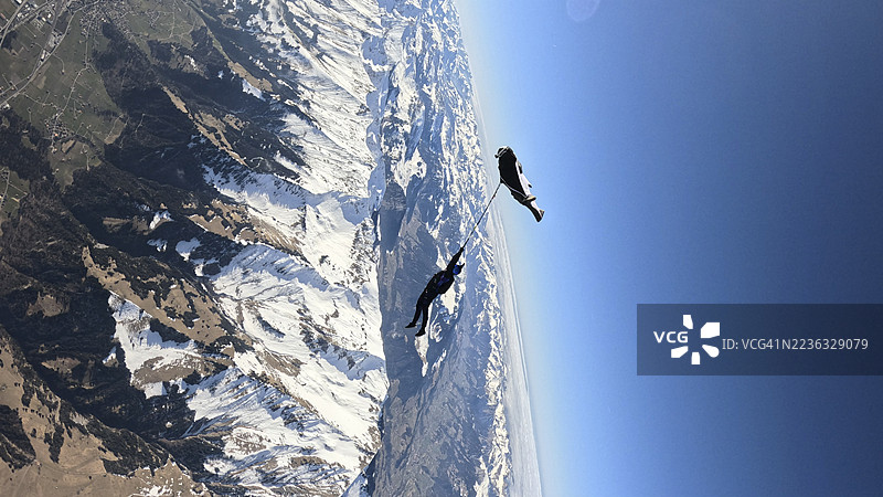空中飞人从飞机上跳下，翱翔在山脉风景之上图片素材