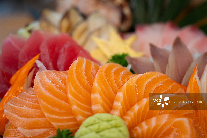 色彩丰富的生鱼片拼盘，包含各种鱼类和蔬菜图片素材