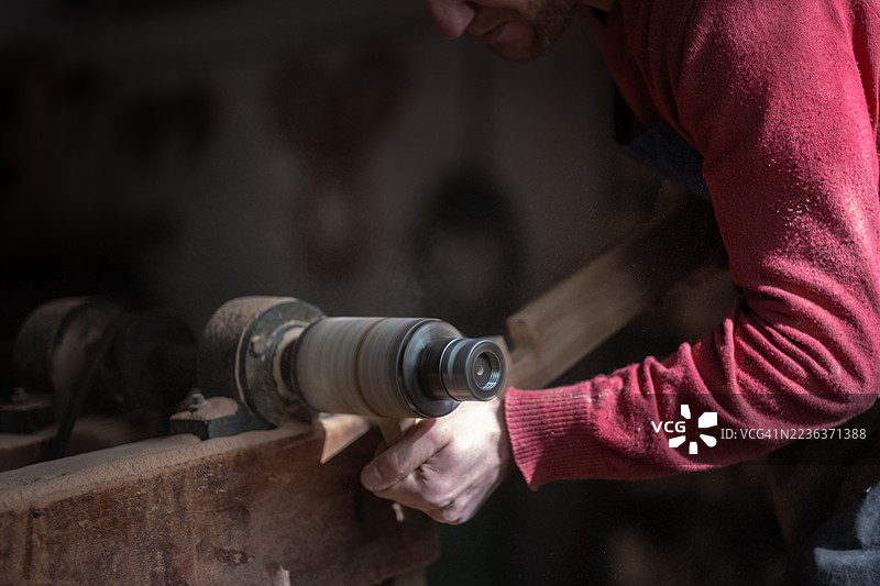 工匠在工作室使用车床制作木制物品图片素材