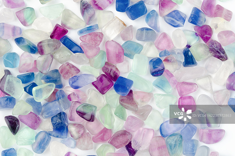 各种不同种类的彩色矿物和半宝石在白色背景上。图片素材