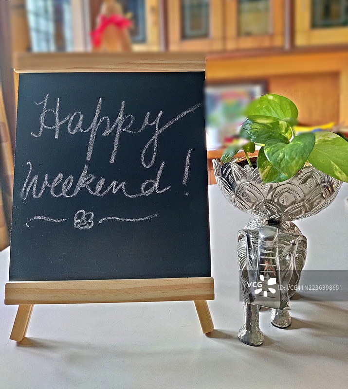 快乐周末/手写文字在黑板上/黑板/石板/吊兰植物/大象雕像/家居装饰/家居室内图片素材