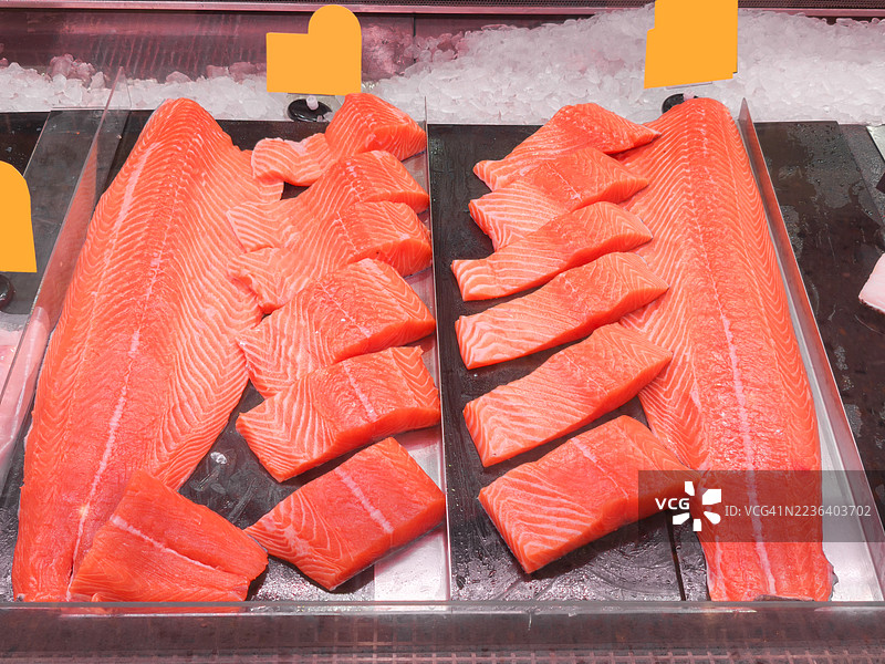 海鲜柜台上的新鲜三文鱼片放在冰上图片素材