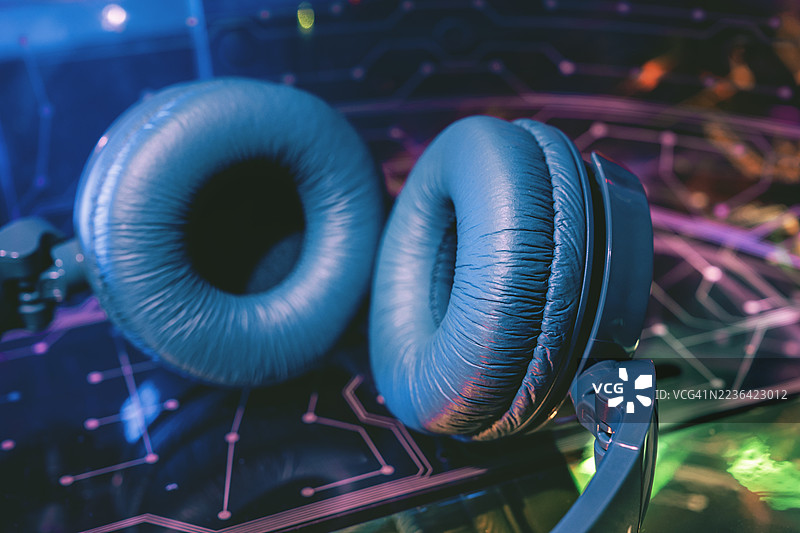 耳机与科技感十足的计算机网格背景。机器学习与全球通信网络。声音与音乐，沉浸式音频学习。图片素材