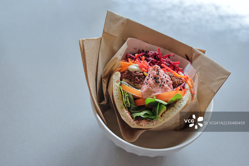 素食皮塔饼三明治，内含沙拉三明治、擦碎的甜菜根和胡萝卜、番茄、混合蔬菜、牛油果、鹰嘴豆泥和芝麻酱图片素材