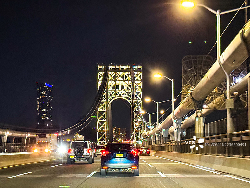乔治·华盛顿大桥上层的汽车，节日时分灯光璀璨的塔楼，纽约市的节日气氛图片素材