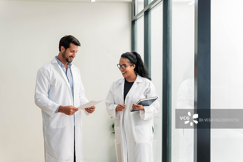 两位热情的，中东和黑人科学家在明亮现代的实验室里查阅数据图片素材