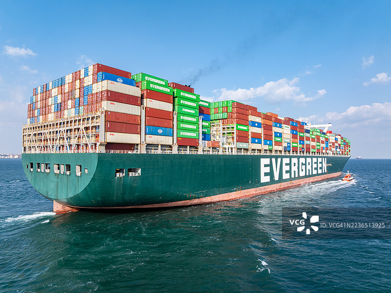 无人机视角下的EVERGREEN集装箱船在青岛城市天际线前航行图片素材