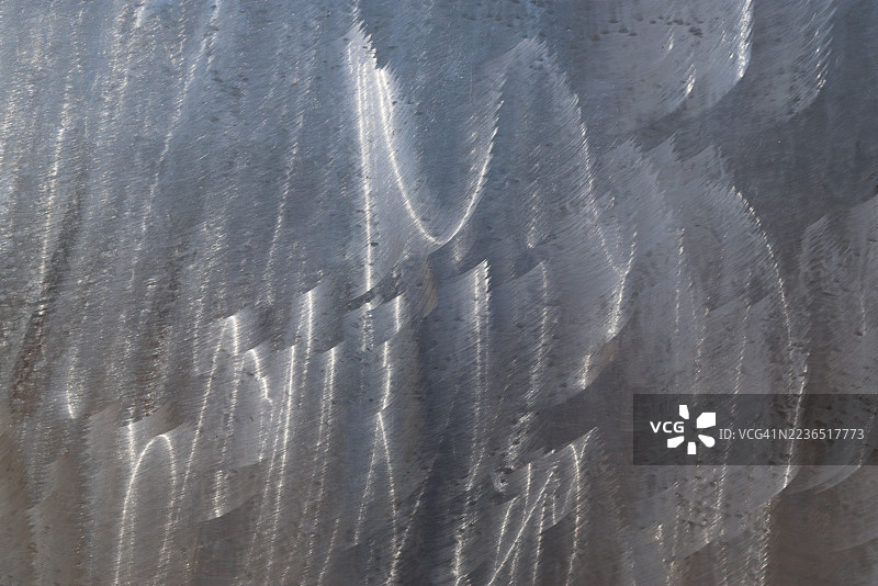 光滑的不锈钢金属表面，带有随机波浪状的拉丝纹理图片素材