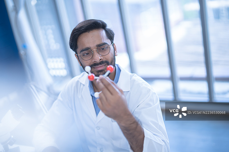 科学家在实验室中分析分子结构，穿着白大褂，强调化学研究和科学创新。图片素材