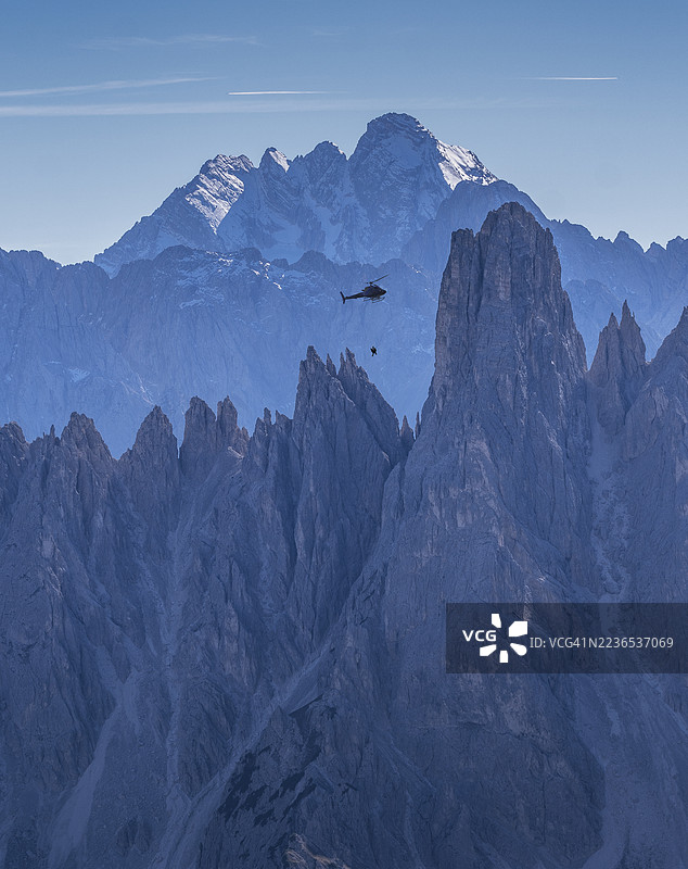 在岩石山脉中被直升机救援的攀登者图片素材