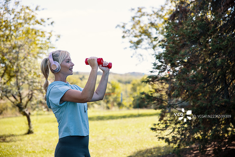 女性在公园里举重锻炼图片素材