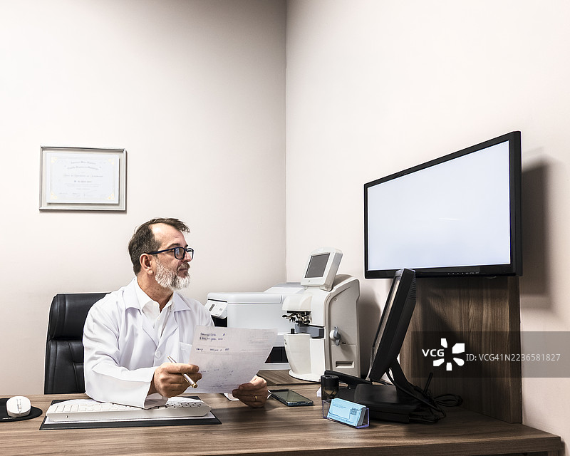 医生在现代诊所办公室的电脑前工作图片素材