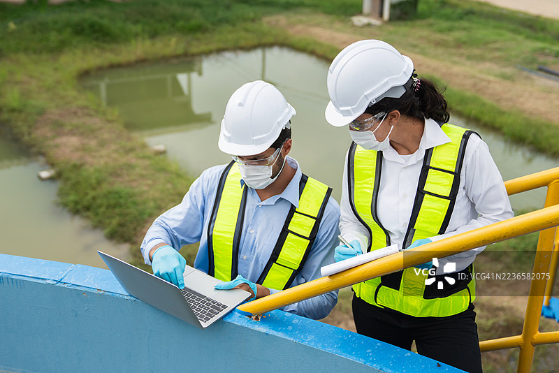 团队在水处理设施工作，采样和监测水质。水处理厂的操作员正在检查和分析水质。图片素材