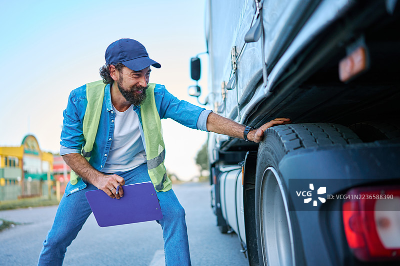 卡车司机检查卡车轮胎以进行安全检查图片素材