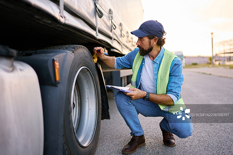 卡车司机检查半挂车轮胎的安全性图片素材