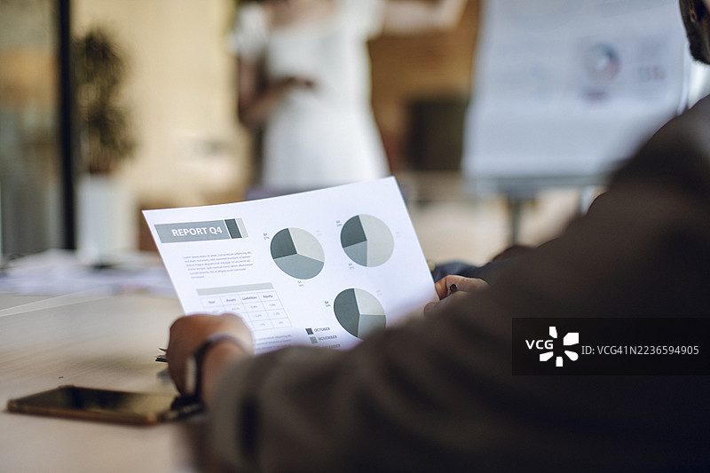 商务人士在办公室环境中审阅季度报告会议图片素材