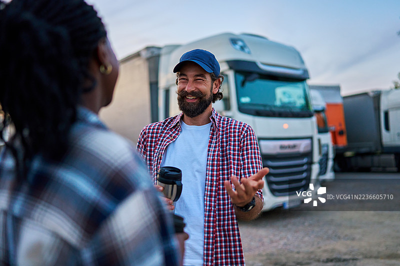 卡车司机在咖啡休息时交谈并微笑图片素材
