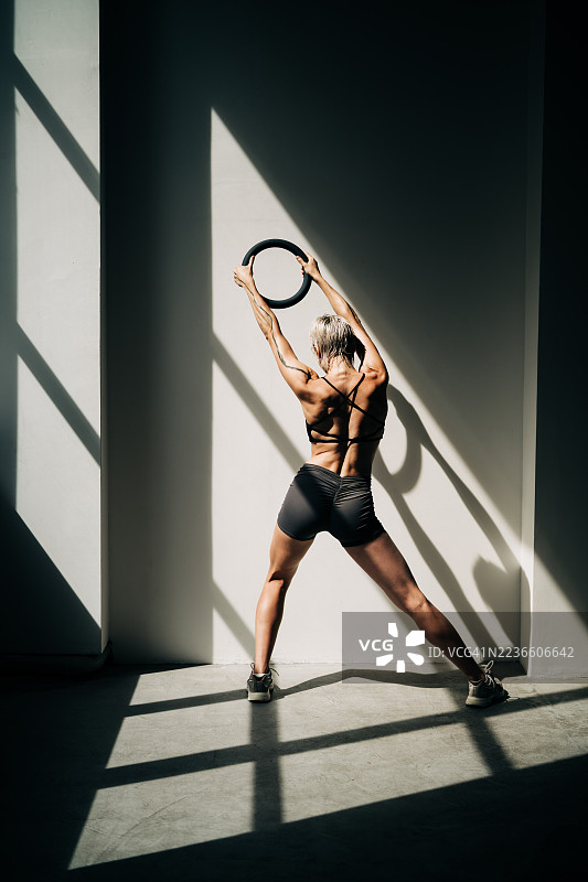 一名女运动员正在使用哑铃进行训练。图片素材