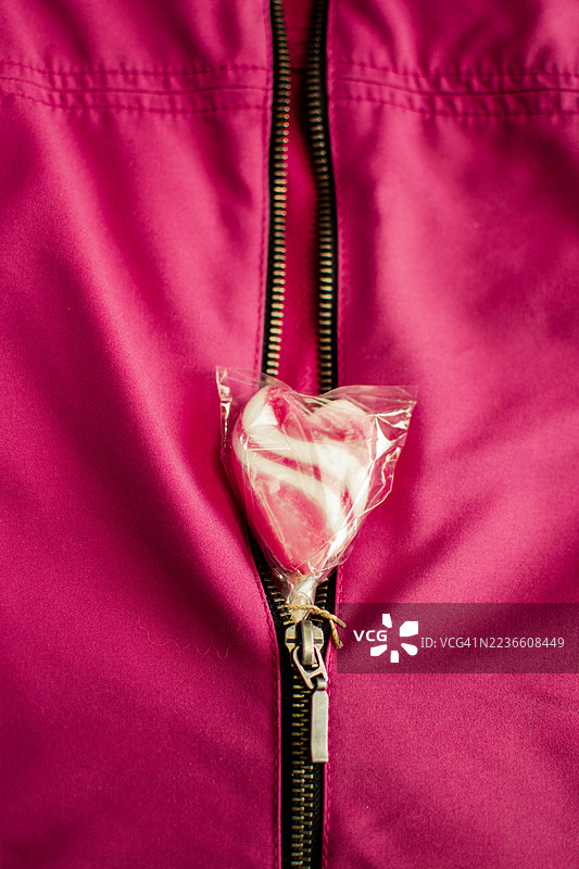 心形棒棒糖从粉色夹克拉链中露出图片素材