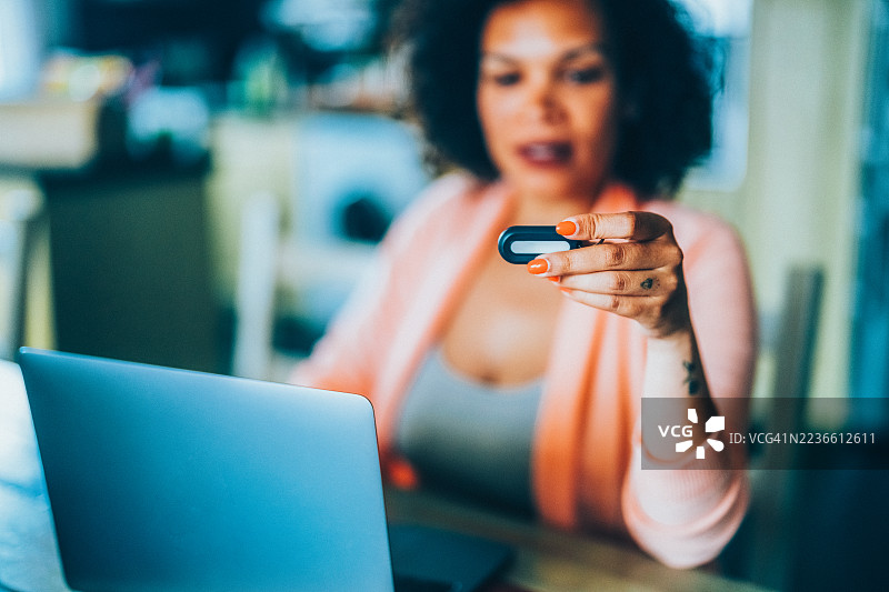 在家中使用硬件钱包进行加密货币交易的女性图片素材