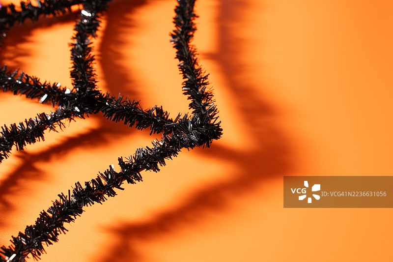 黑色闪光蜘蛛网万圣节装饰在橙色背景上图片素材