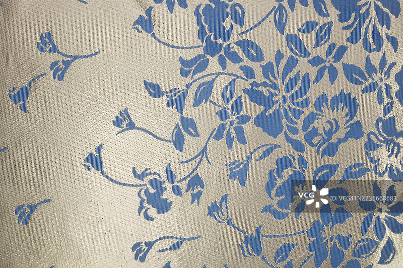 蓝色花卉图案的面料，背景为米色图片素材