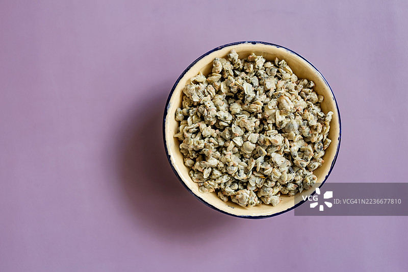 一碗煮熟的小蛤蜊，背景为紫色图片素材